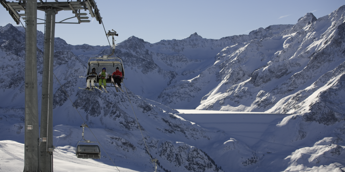 Sessellift im Skigebiet, im Hintergrund sind weiße Berge
