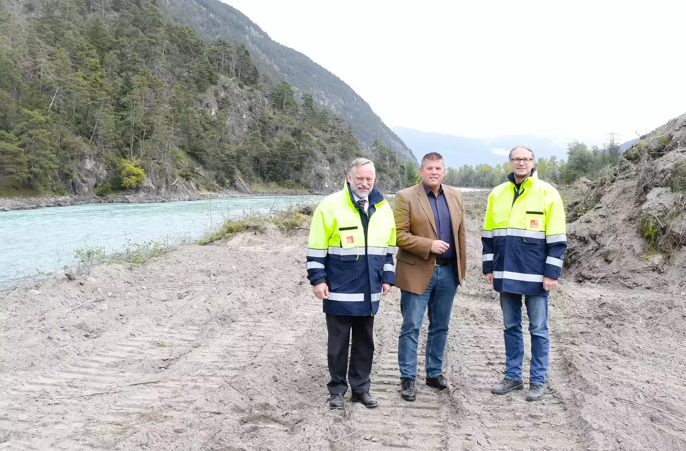 TIWAG-Vorstandsdirektor Johann Herdina (li.), Bürgermeister Markus Rinner und TIWAG-Projektleiter Klaus Feistmantl (re.) erläutern die geplanten Maßnahmen auf dem Flussab-schnitt zwischen Stams und Rietz.